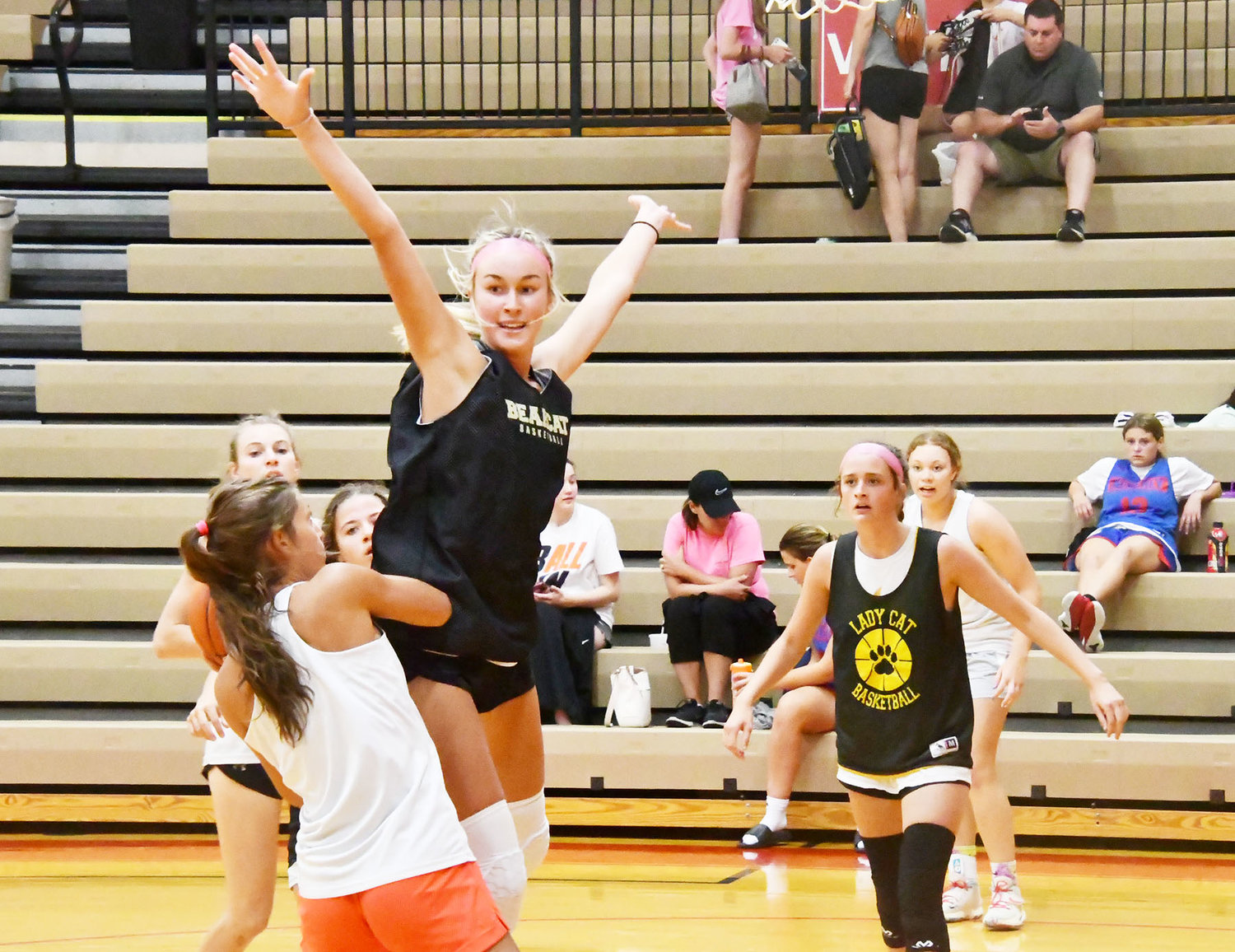 Macie Harman jumps out and defends a Hermann player while Jersey Bailey looks on at right.
