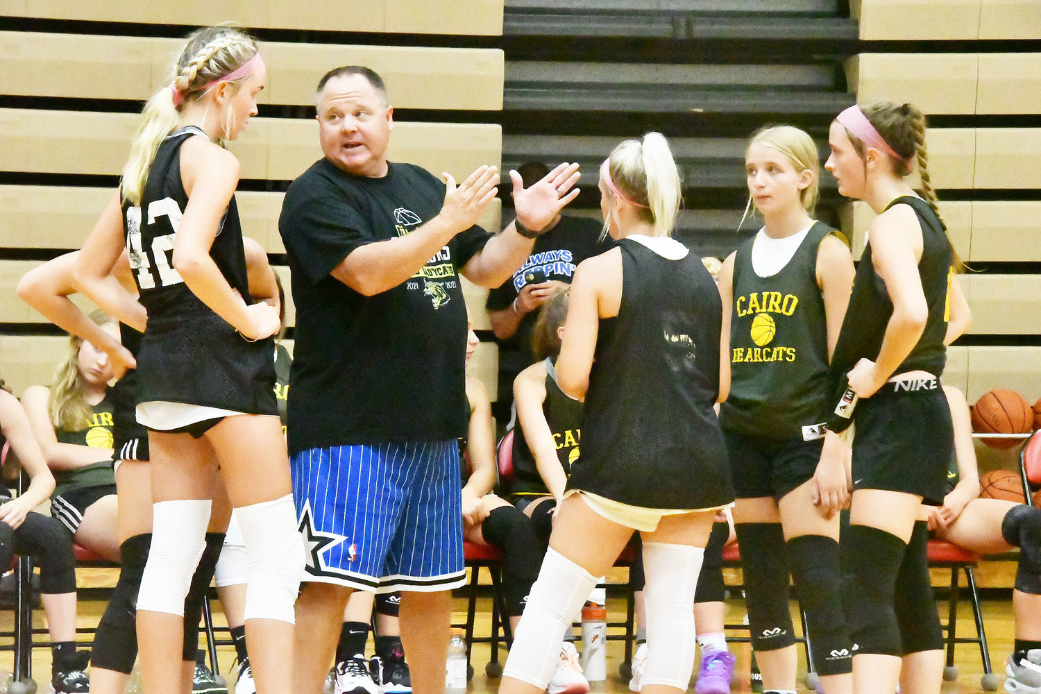 Cairo head girls' basketball coach Brian Winkler motions during a timeout while Macie Harman, Gracie Brumley, Addison Bailey and Jersey Bailey listen.