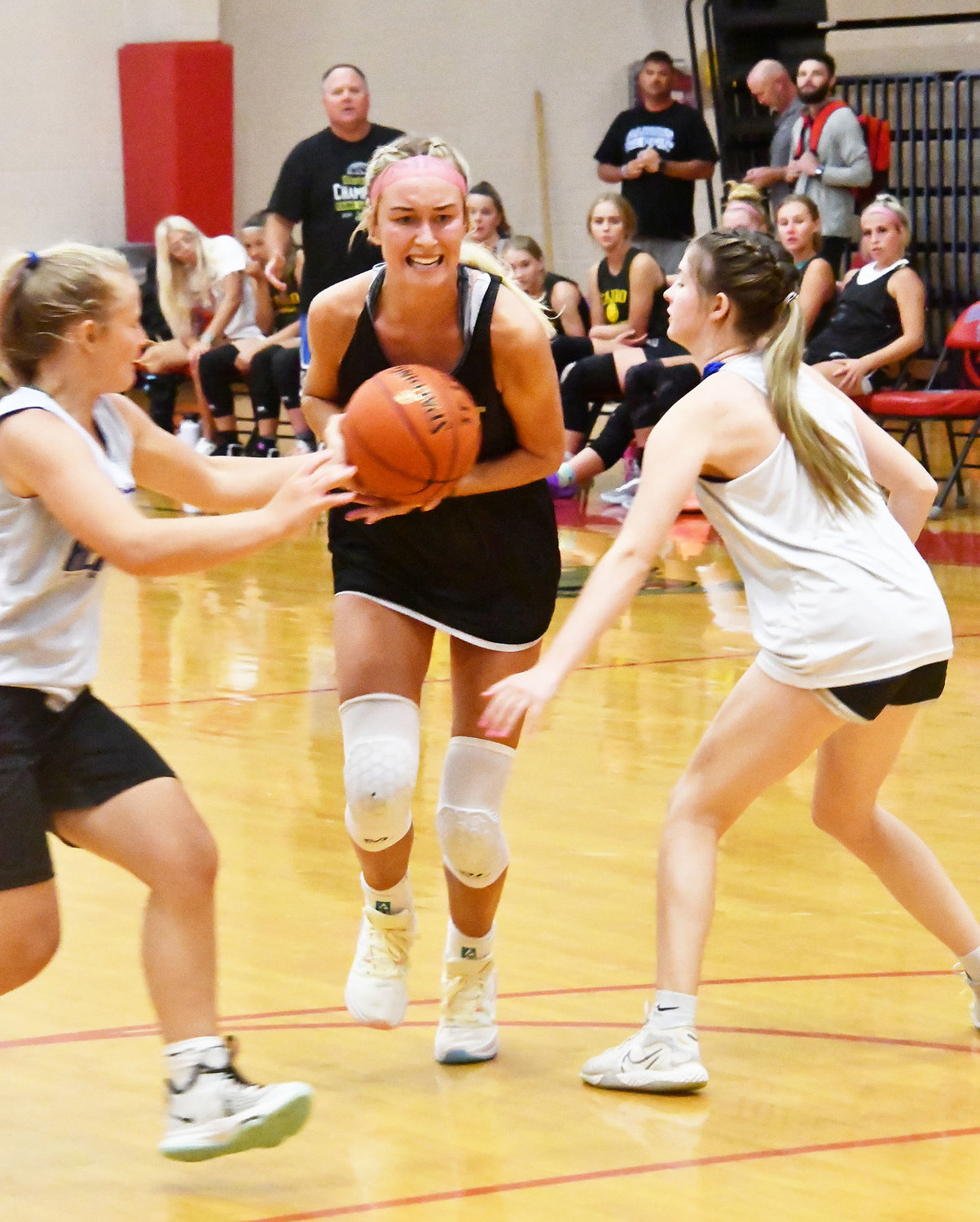 Macie Harman possesses the ball while fighting off a Hermann's double-team trapping defense.