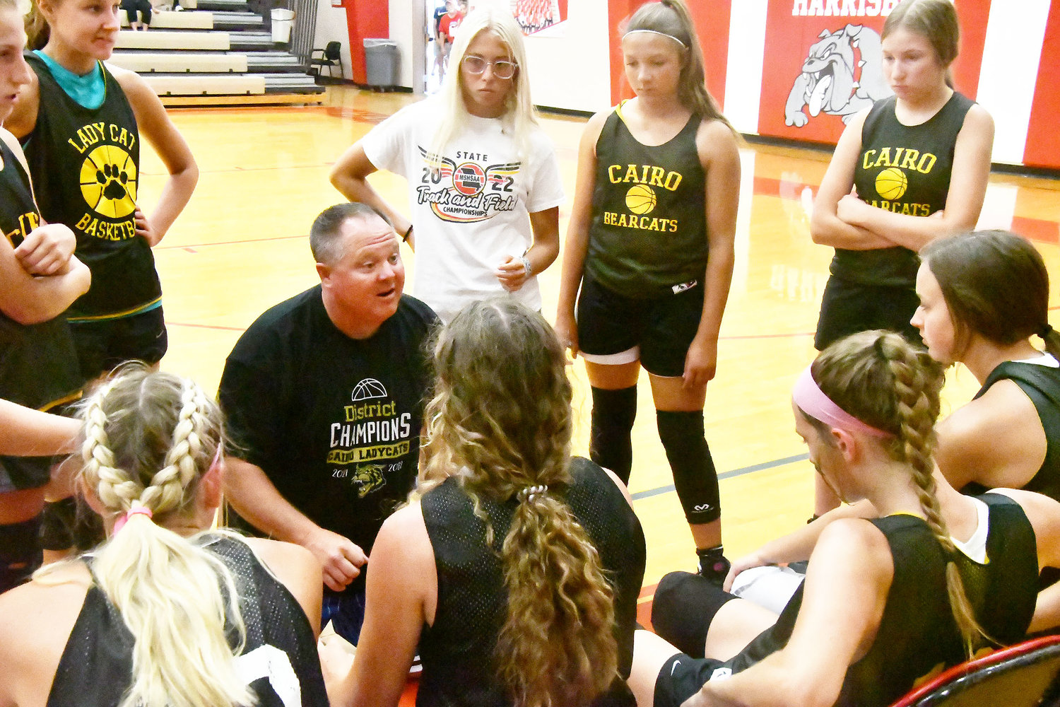 Cairo coach Brian Winkler talks to the team during a timeout. Looking on are Kennedy Kearns, Avery Brumley, Mallory Hankins and Melia Gittemeier.
