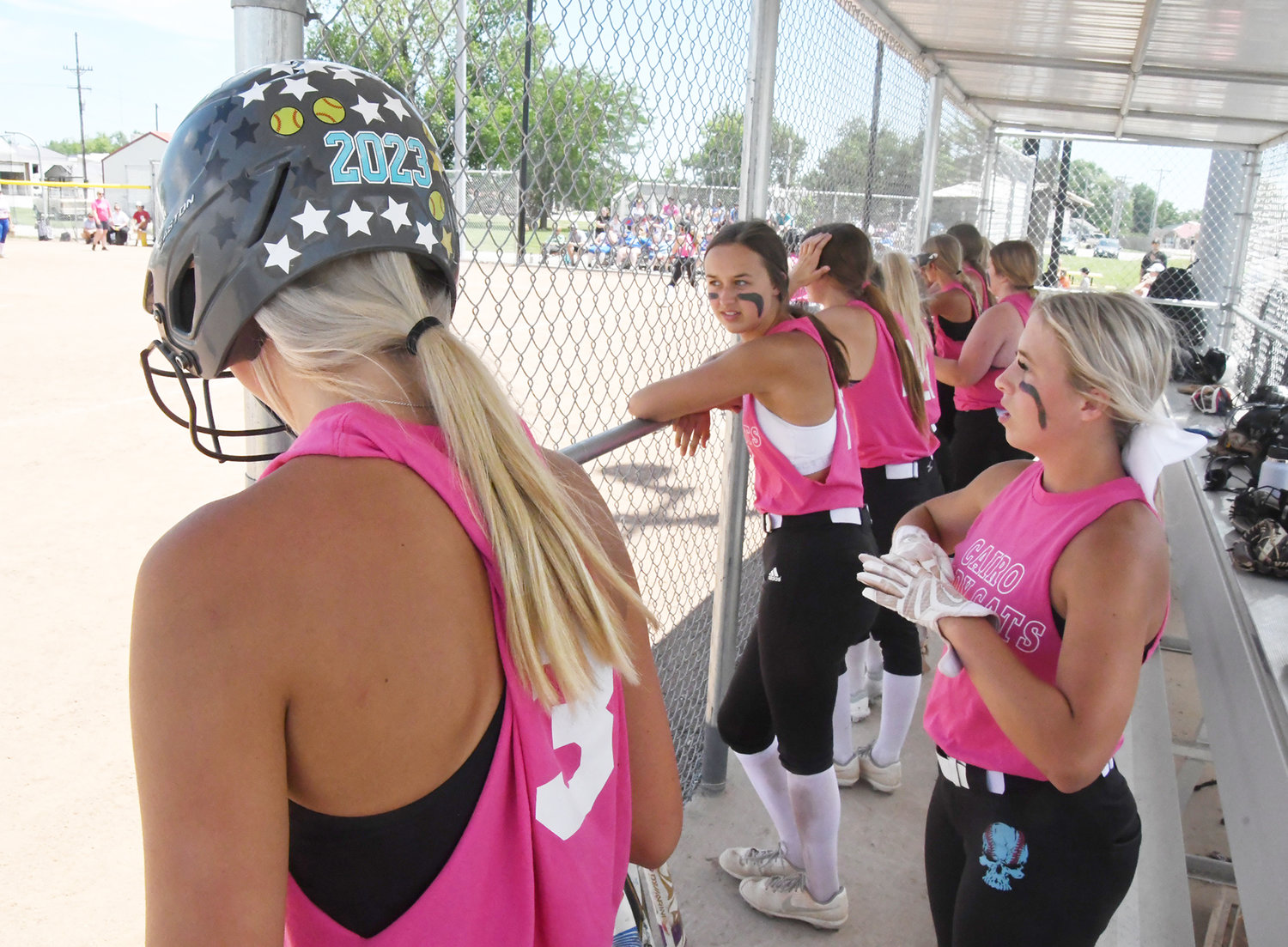 From left, Iszy Zenker, Paige Westhues and Gracie Brumley watch a teammate bat from the dugout during a scrimmage on Monday, June 27, in Cairo.