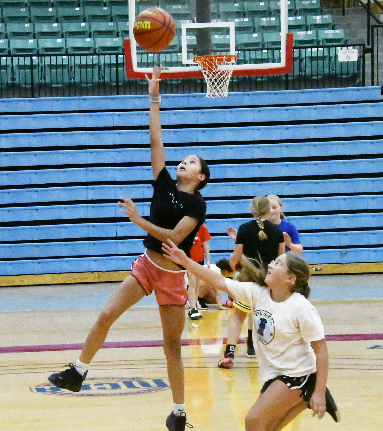 Arionna Rucker leaps into the air while attempting a layup during a one-on-one game.