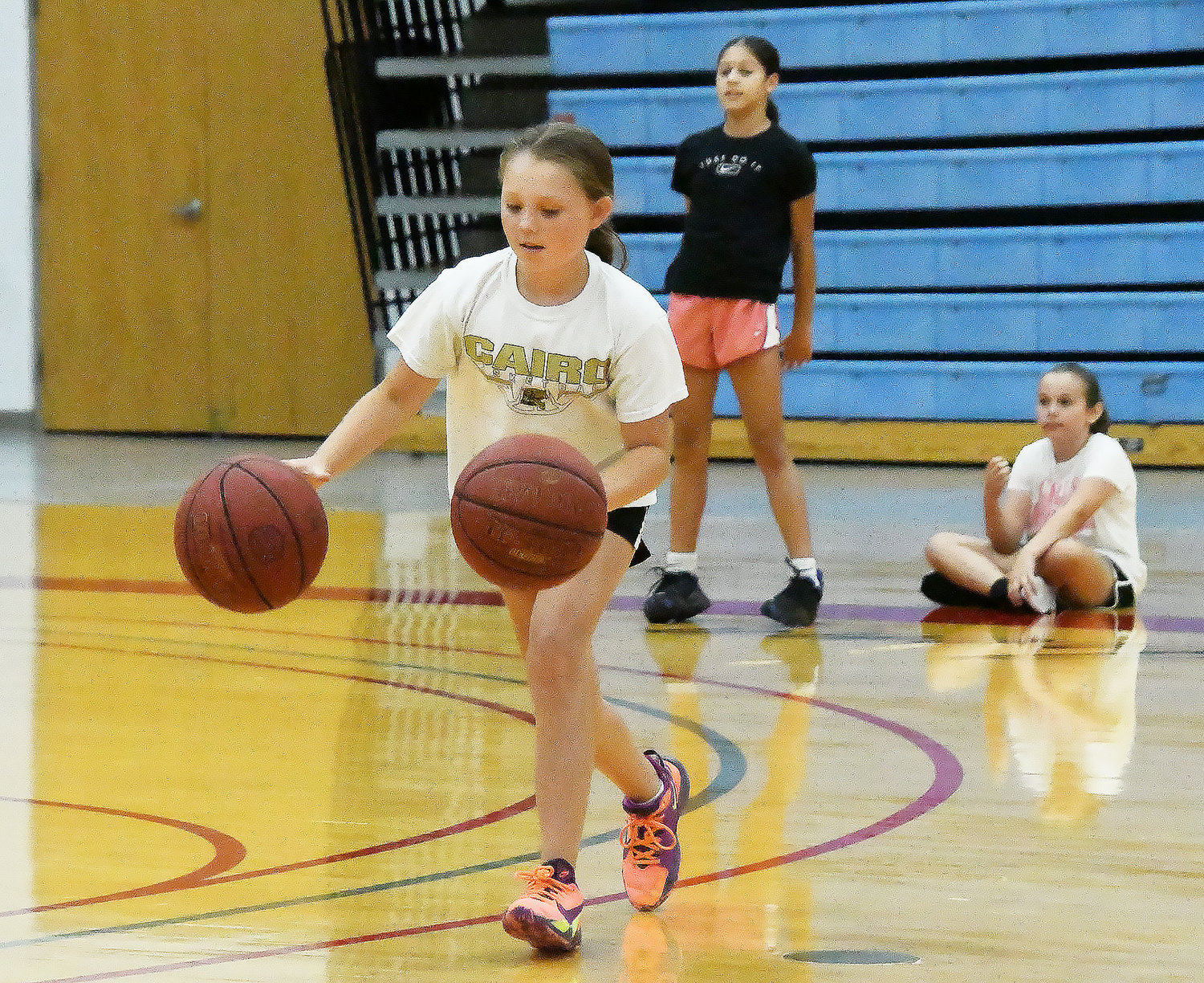 Mazy Jaecques dribbles two basketballs at the same time during a drill.