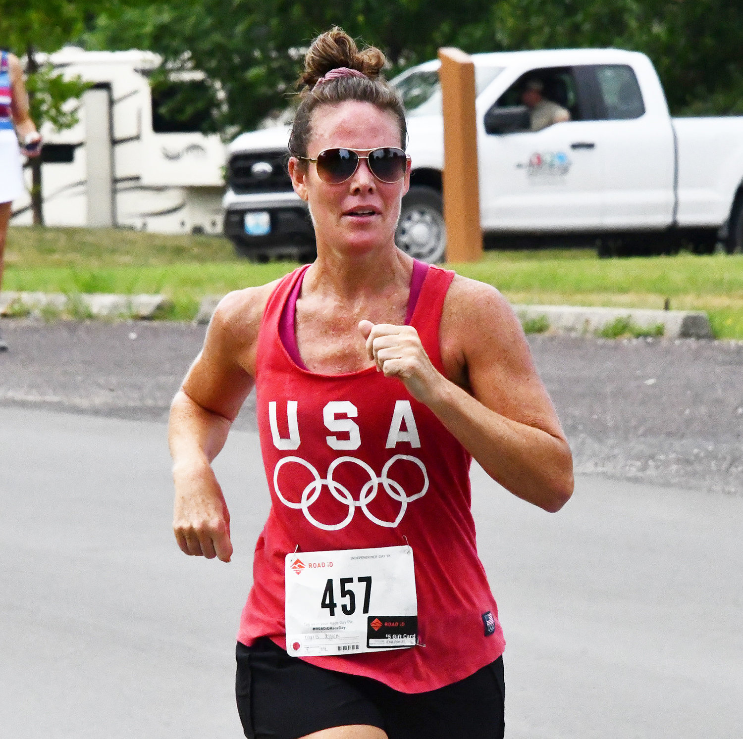 Jessica Morris, wearing a USA Olympic tank top, races toward the finish line in Rothwell Park on Monday, July 4.