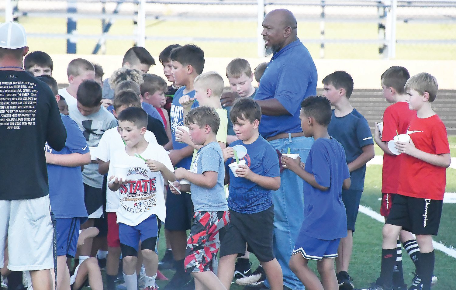 Bobby Godwin (blue shirt, center) has transitioned into the role of Little Spartans football commissioner. Godwin recently reported the tackle football and cheerleading organization needs 16 coaches for its football program, with four per grade level from third through sixth grade. Godwin is shown here during the Little Spartans’ football camp at Dr. Larry K. Noel Spartan Stadium on Thursday, July 21.
