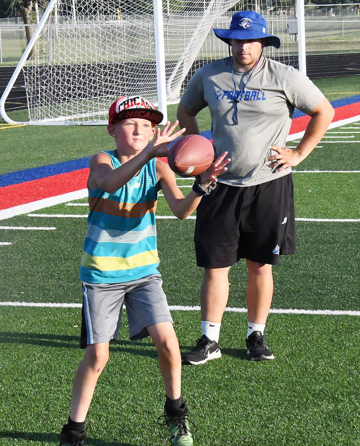 Under the watchful eye of the Moberly High School coaching staff, a wide receiver catches a pass.