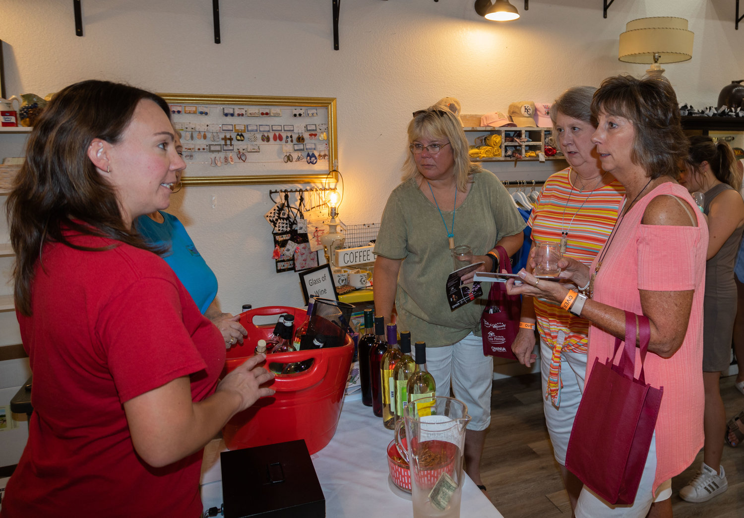 Heather Thewlis and Pam Reams discuss Hummingbird wines with Mary Stallman, Tracie Gittemeier and Rhenda Weis during Saturday’s Wine Stroll. The event raised money for Safe Passage, a nonprofit organization that serves victims of abuse.