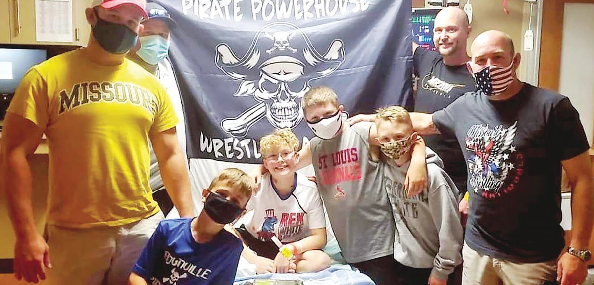 During the North Central Youth Football League jamboree slated for Aug. 27-28, there will be a benefit collection for Hunter Simmons (center). Simmons is a soon-to-be fifth-grader from Boonville who was diagnosed with leukemia earlier this year. Simmons is photographed with (from left) Tyler Schanzmeyer, Owen Schanzmeyer, Joey Bishop, Brad Bishop, Breydon Keys, Josh Keys and Brad Simmons. Hunter was given a Pirate Powerhouse Wrestling Association flag.
