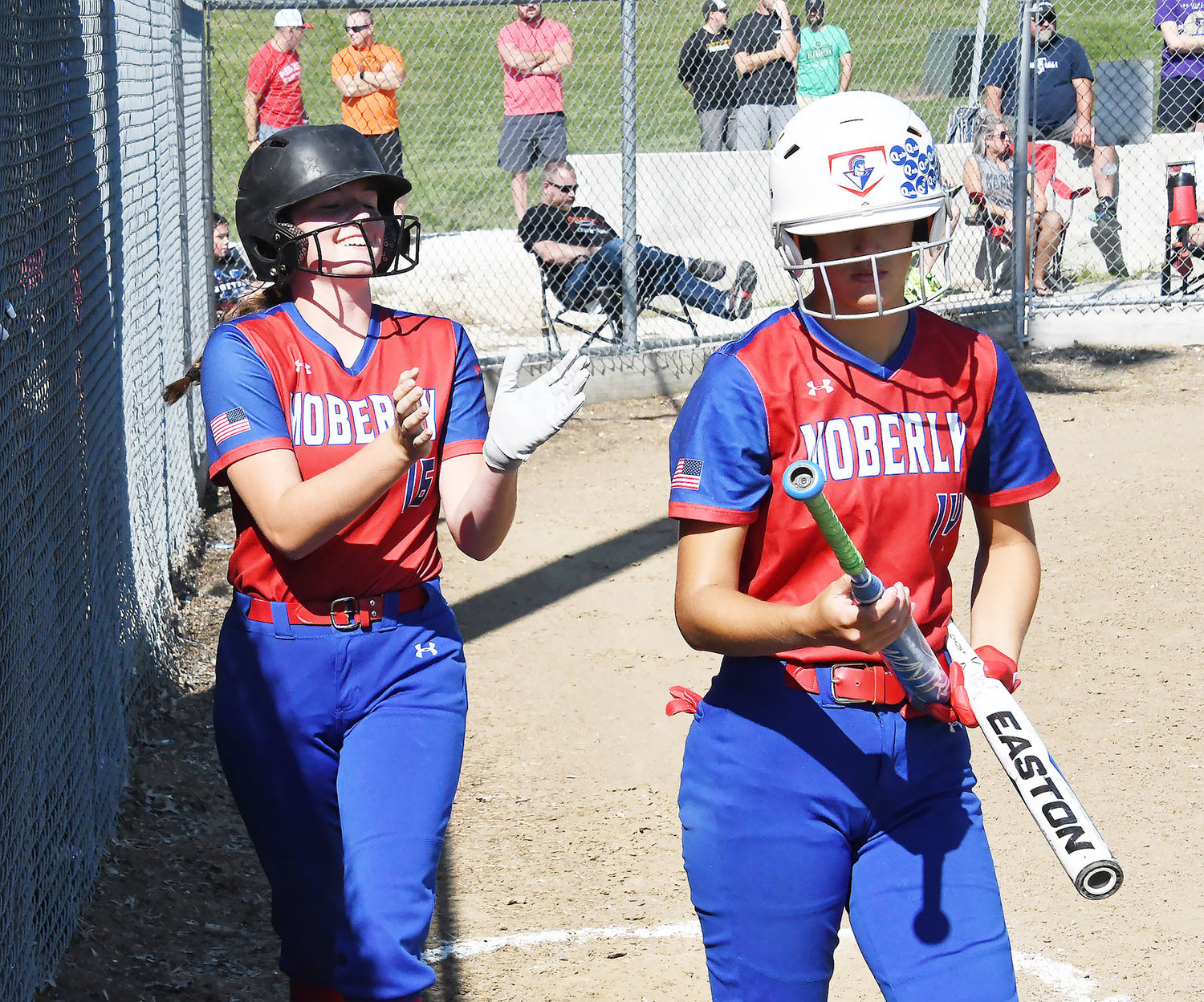 Hannah Ramsey smiles and claps after scoring a run for the Spartans. Chloe Ferguson also is photographed, at right.