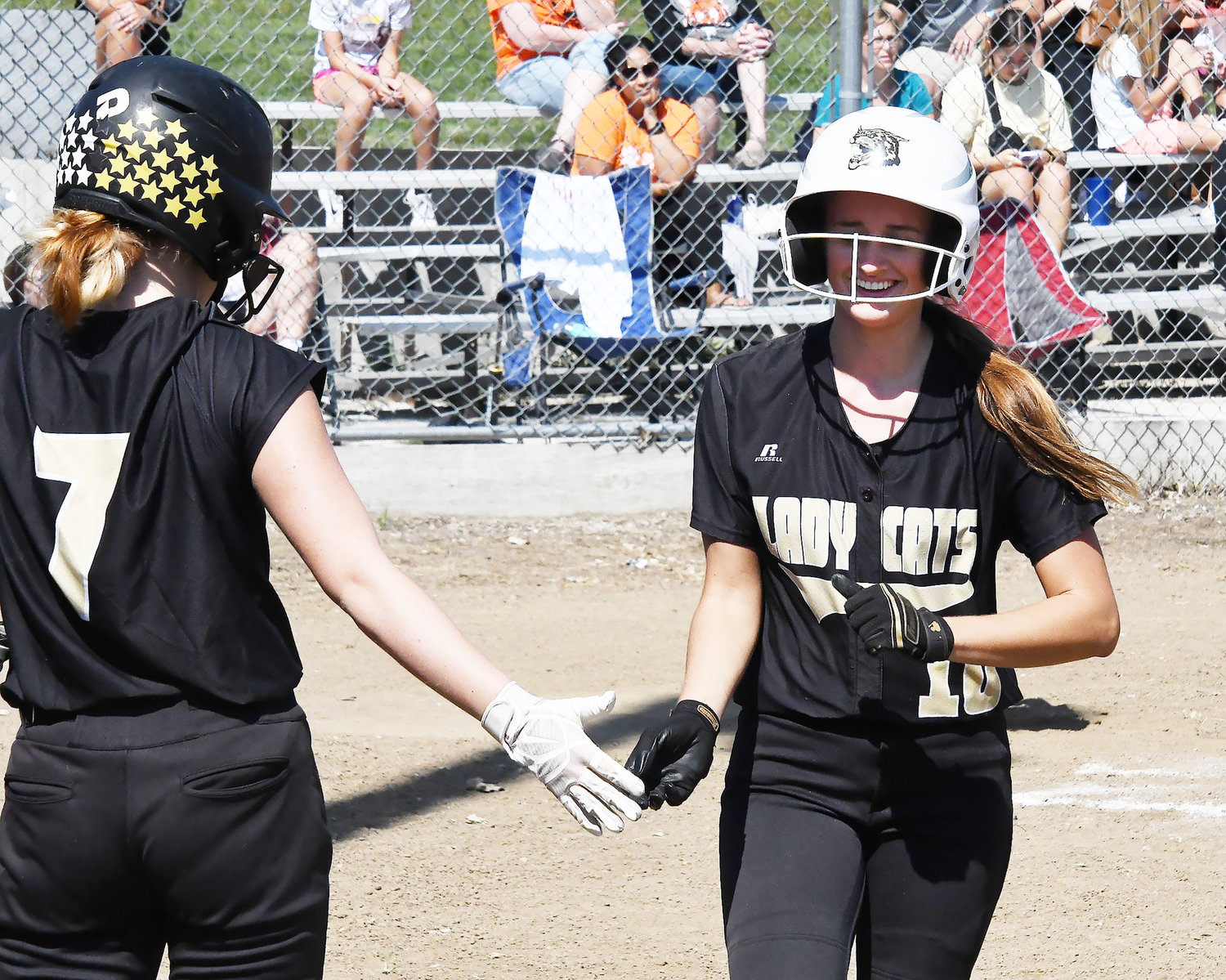 Jersey Bailey (10) smiles after pushing across a first-running run, congratulated by teammate Abi Ogle.