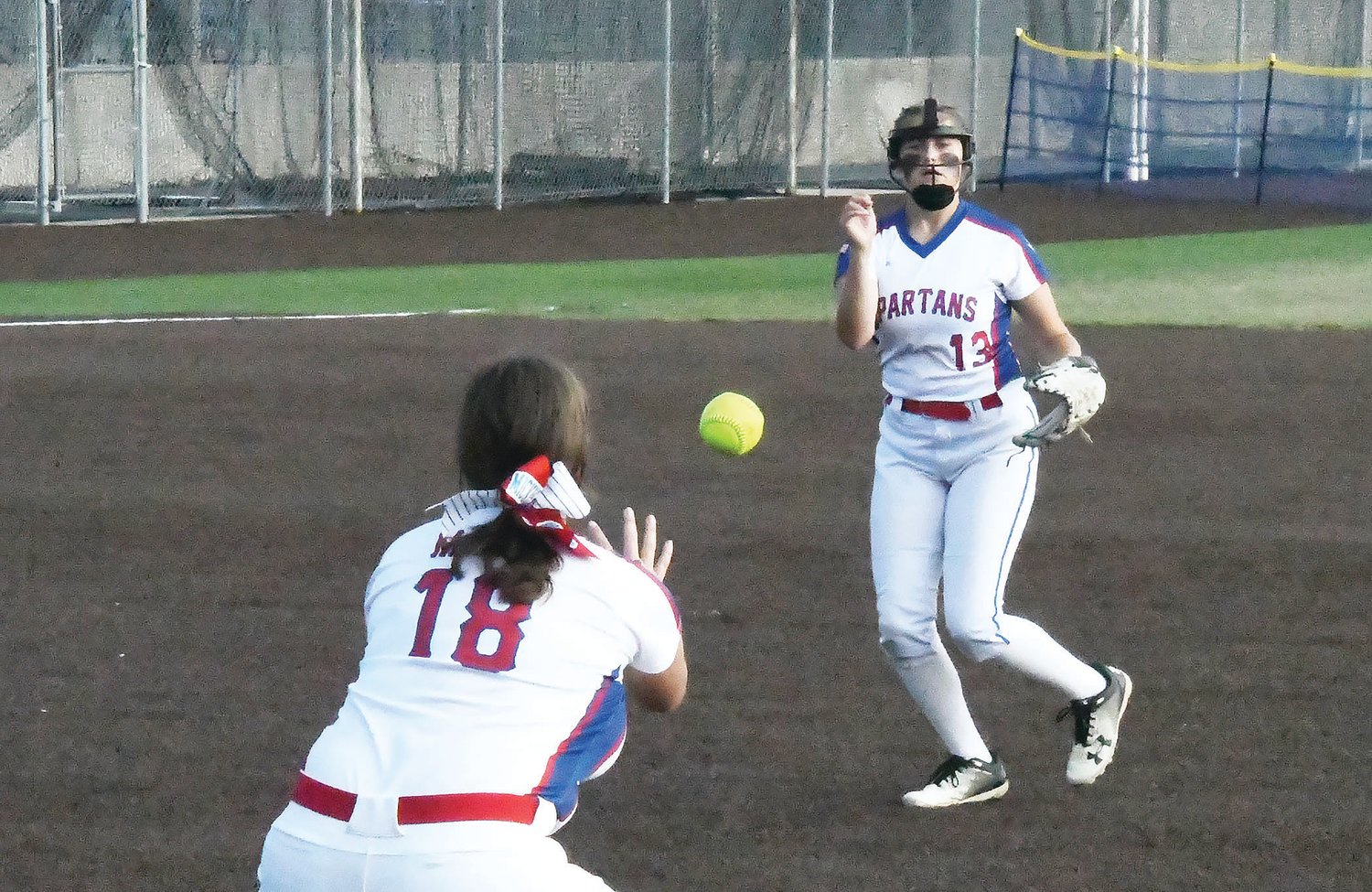 Moberly High School second baseman Elizabeth Reisenauer (13) tosses the ball to Jade Mickle (18) for a putout during Tuesday’s North Central Missouri Conference game against Hannibal. The Spartans downed the Pirates, 7-3, for their first win of the season.