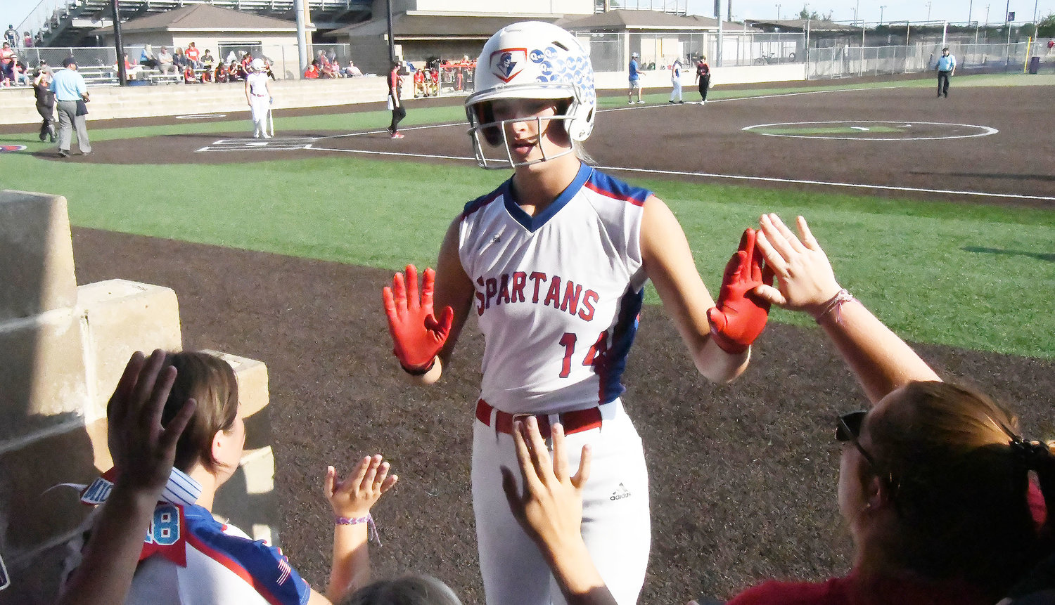 Moberly High School’s Chloe Ferguson (14) receives congratulations from her teammates after scoring a run during Tuesday’s game versus Hannibal at General Omar Bradley Field.
