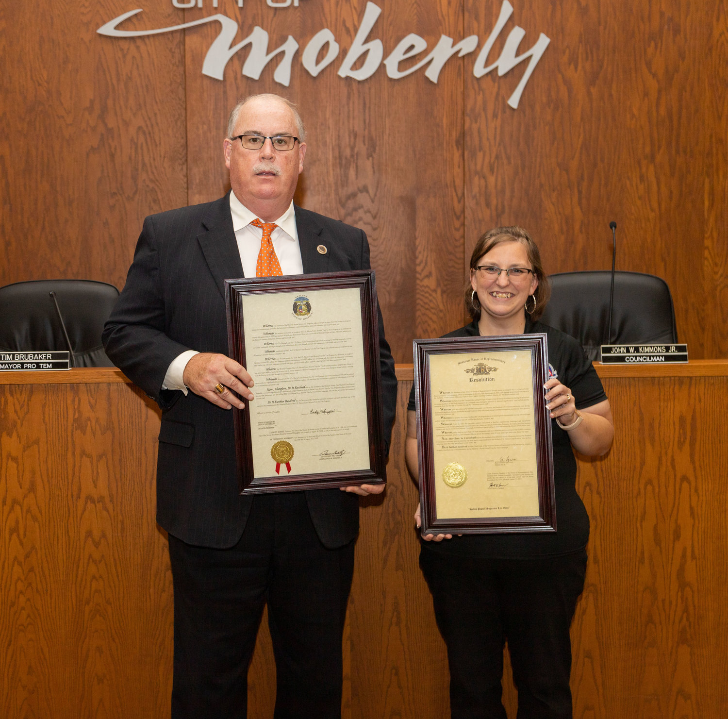 Moberly Mayor Jerry Jeffrey and Toys for Tots Coordinator Carma Palmer display resolutions passed by the Missouri House and Senate recognizing Marine Corps Reserve Toys for Tots Foundation for 75 years of service.