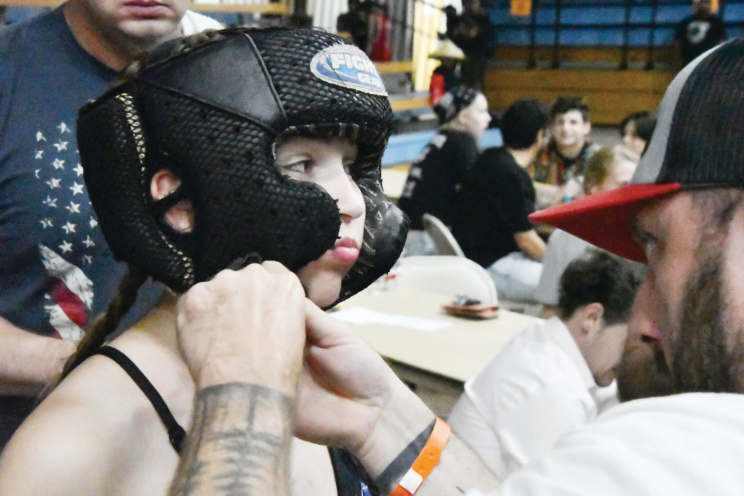 Fight promoter Ricky Davidson adjusts Addison Orscheln's headgear before her kickboxing exhibition versus Aryanna Kimball. Orscheln is a 16-year-old Moberly High School student.