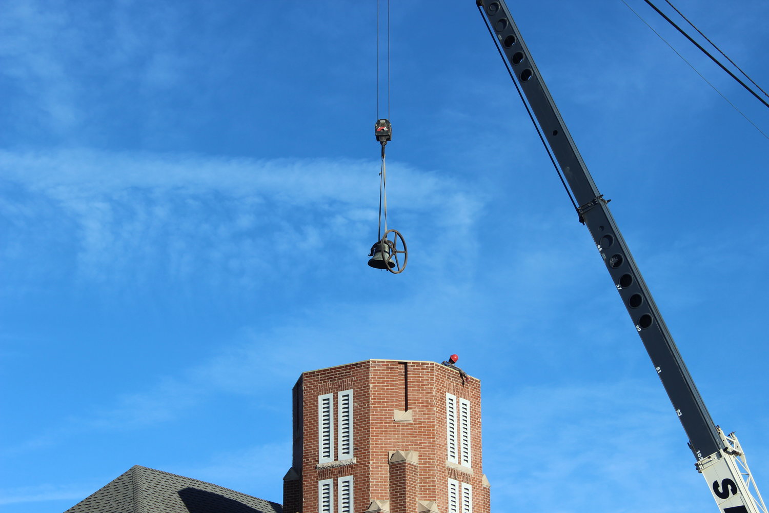 The bell is lowered into the bell tower of Coates Street Presbyterian Church in Moberly Monday in preparation for the new steeple.