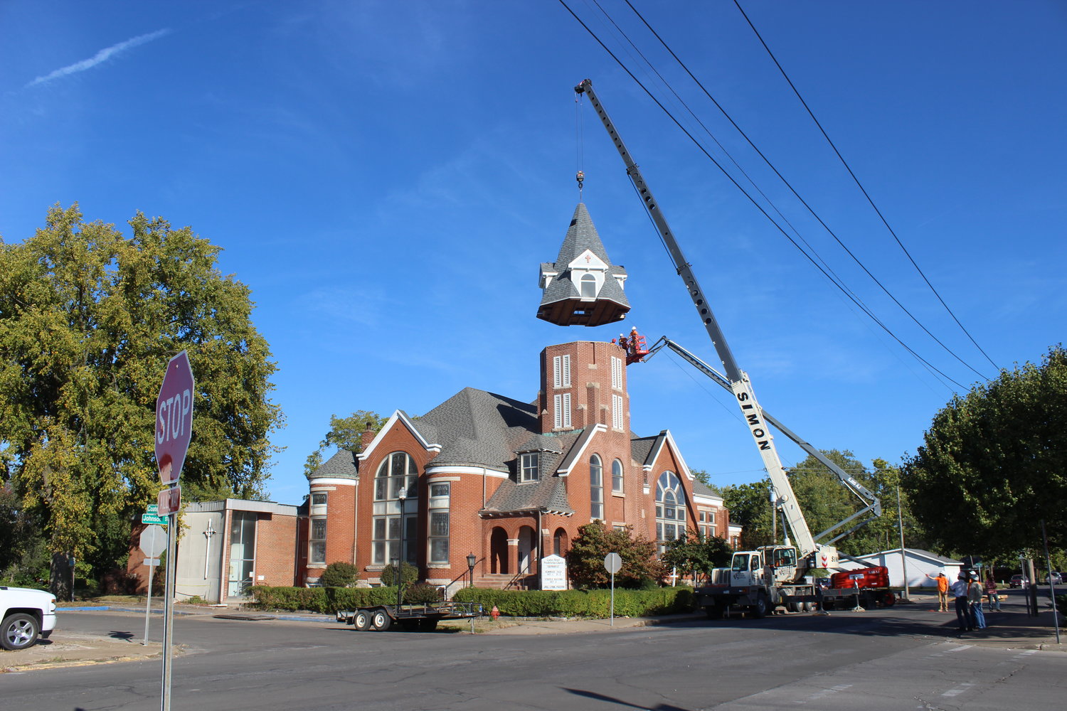 The steeple is lowered onto the bell tower at Coates Street Presbyterian Church. The new steeple replaces one destroyed by a lightning strike in 2019.