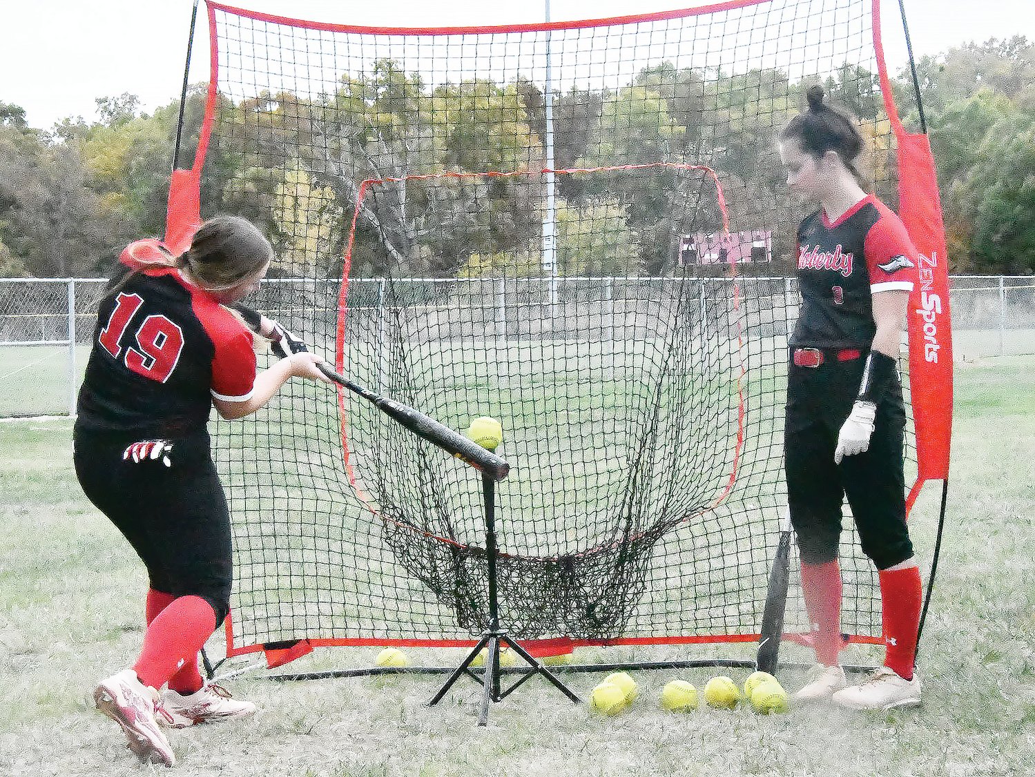 Moberly Area Community College's Abby Reed works on her swing in between games.