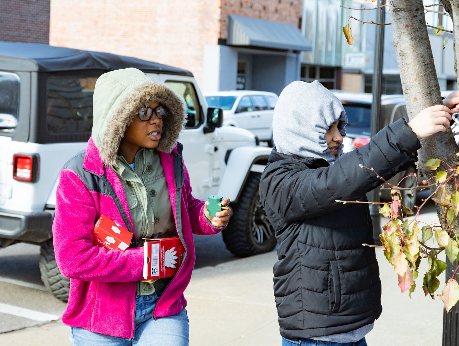 Juniors Nila Winn and Selina Minnis put lights on a tree in downtown Moberly. More than 100 high school students helped decorate downtown Friday.