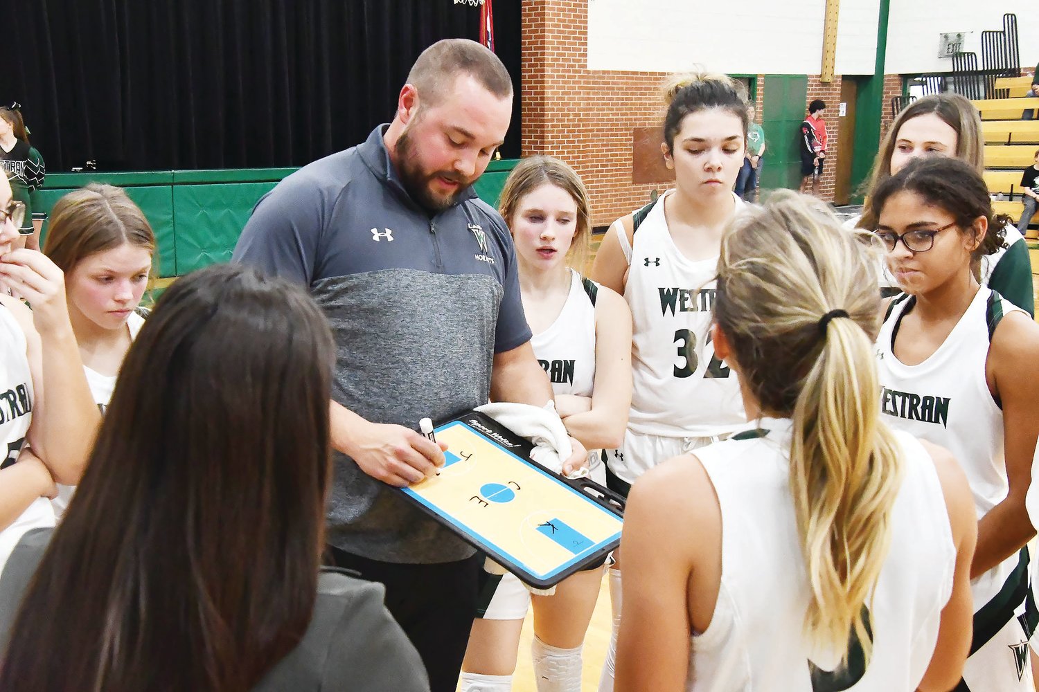 Westran head girls' basketball coach Alex Thomas draws up a play during a timeout.