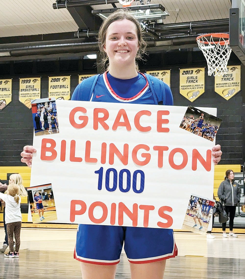 Moberly's Grace Billington shows off a handmade sign after Monday's game versus Monroe City. Billington swished a 3-pointer to surpass 1,000 points in her career, and she's just a junior.