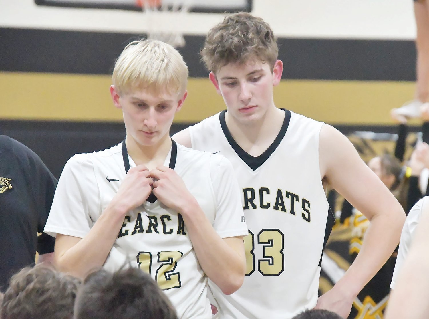 Logan Luecke (left) and Bryce Chrisman listen as head coach Nic Zenker talks during a timeout in last Thursday's game.