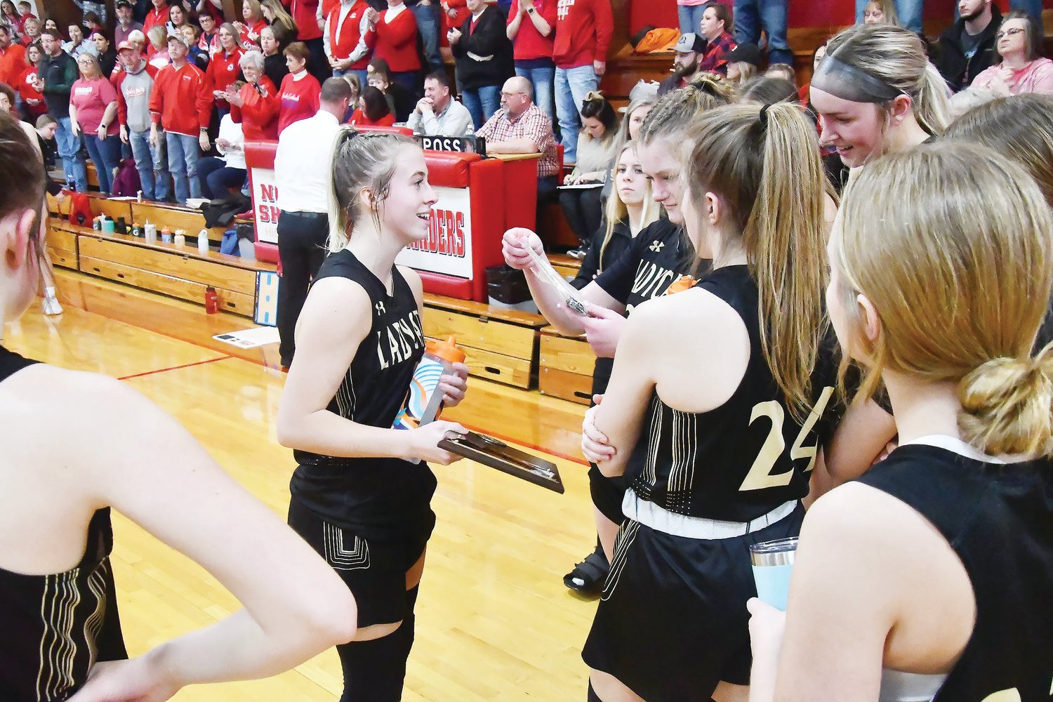 Gracie Brumley takes the second-place plaque to her team after Saturday's girls championship game at the North Shelby Tournament in Shelbyville.