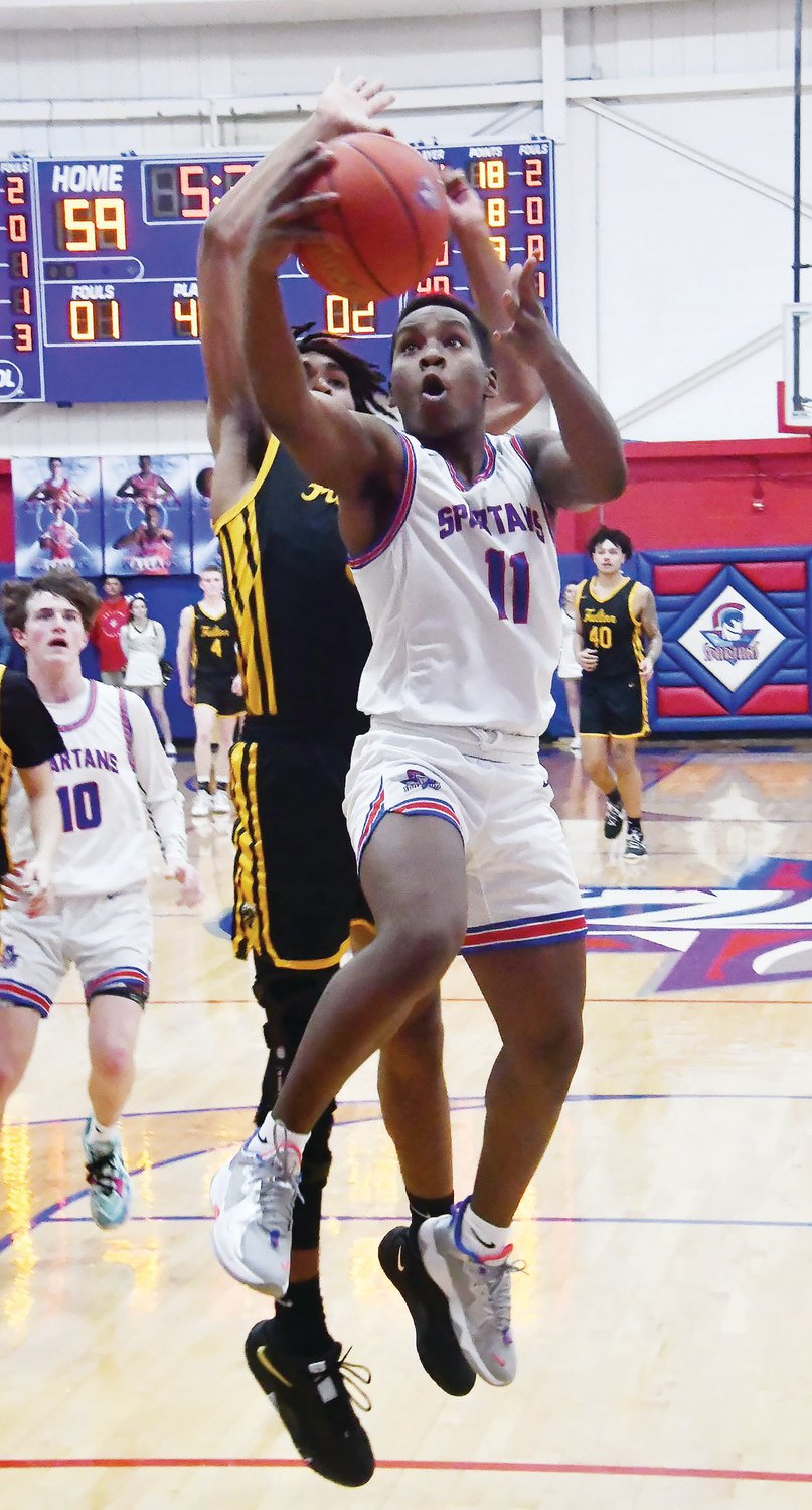 Moberly High School's Derieus Wallace (11) drives to the basket while Fulton's Donovan Weigel plays defense during a North Central Missouri Conference boys basketball game on Tuesday, Jan. 17.
