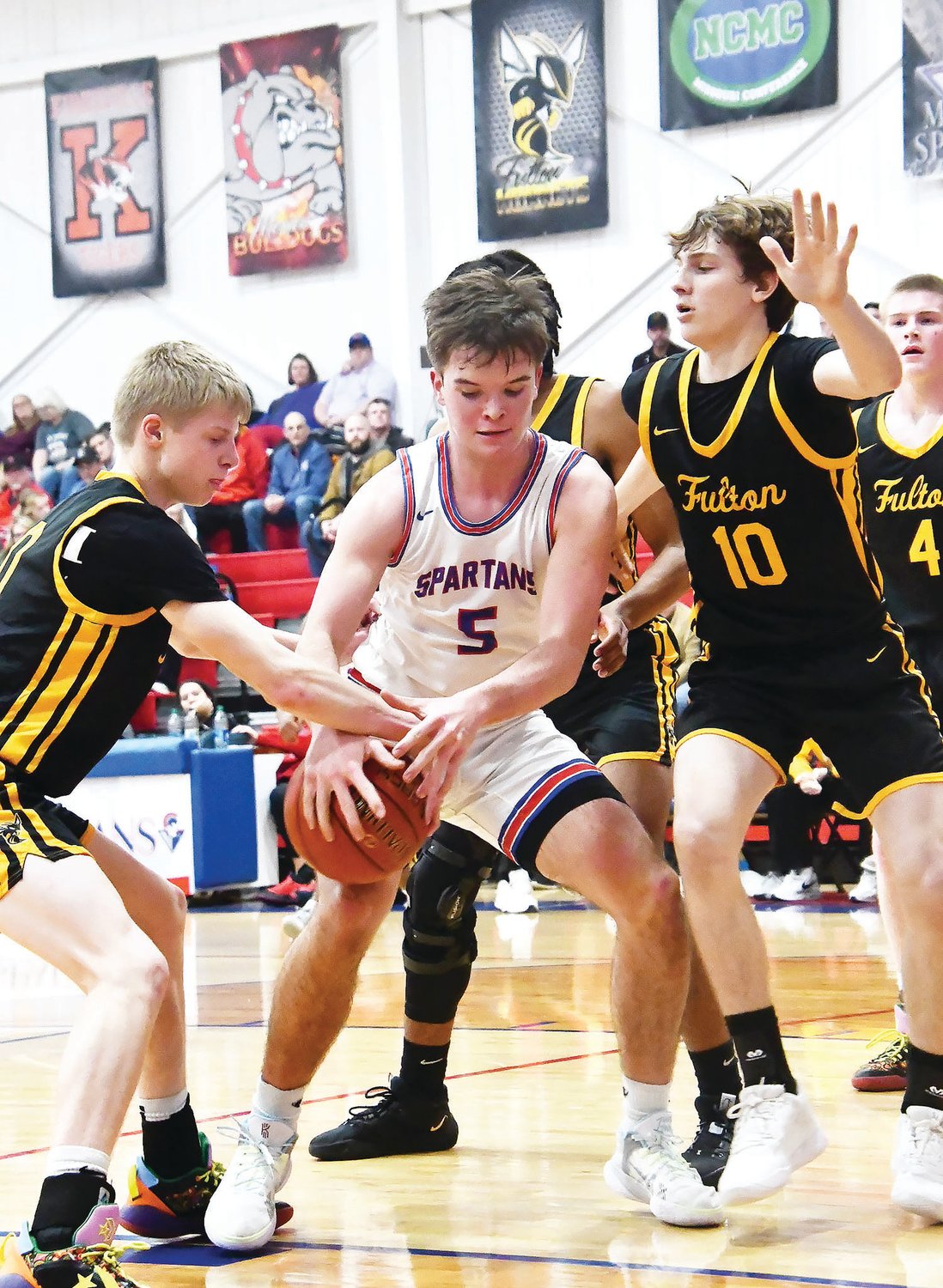 Collin Huffman of Moberly attempts to gather a rebound while harassed by two Fulton players during a conference game on Jan. 17.