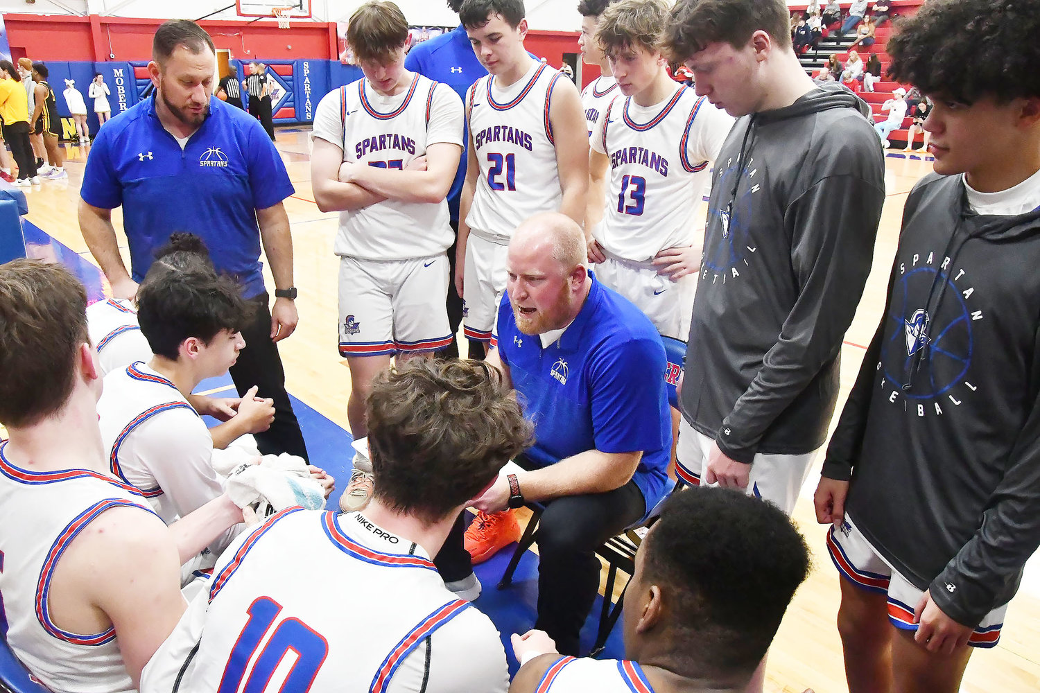 Moberly High School head boys basketball coach Brett Boyer talks with his team during a timeout in second-half action.