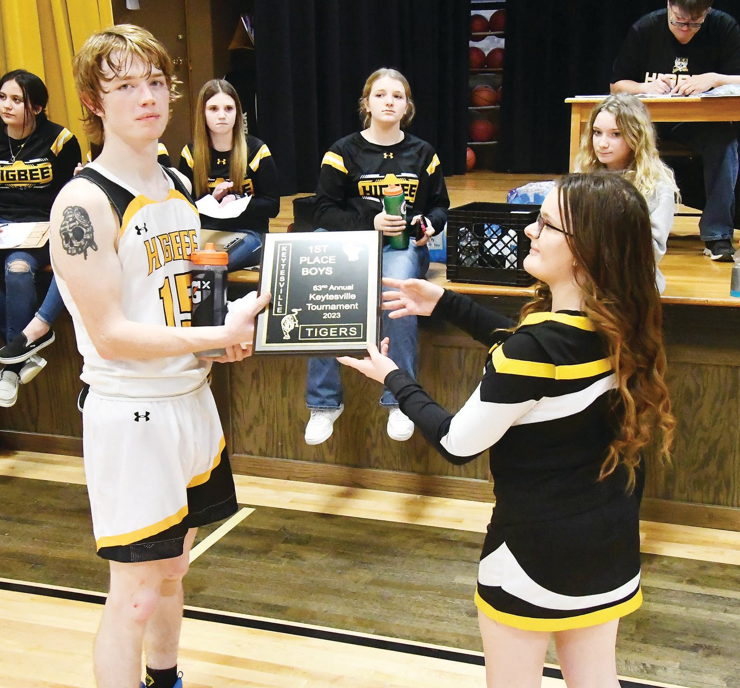 Higbee's Chad Crawford accepts the first-place plaque from a Keytesville cheerleader.