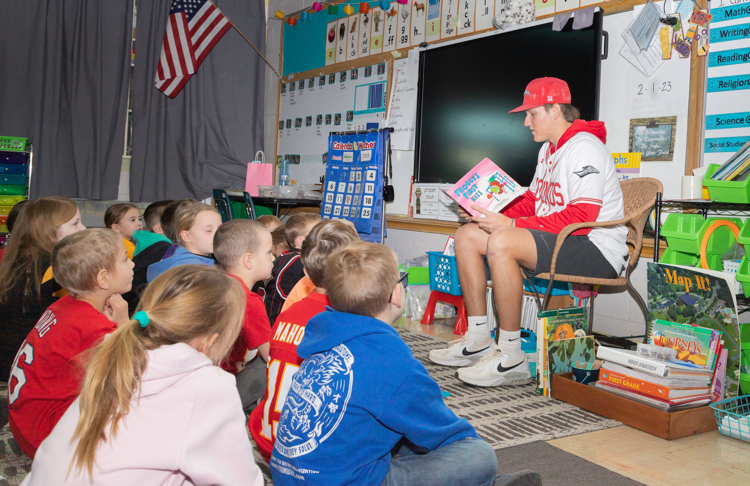 Kaden Lawson, an infielder for the Moberly Area Community College baseball team, reads to first graders at St. Pius X Catholic School in Moberly. Ten Greyhounds read to students Wednesday as part of Catholic Schools Week.