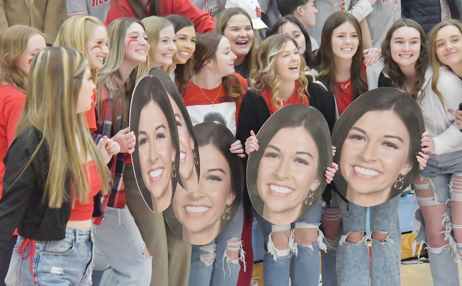 Moberly Area Community College head women's basketball coach Hana Haden is surrounded by members of the Greyhound softball team, who made "Fatheads" out of the coach's image.
