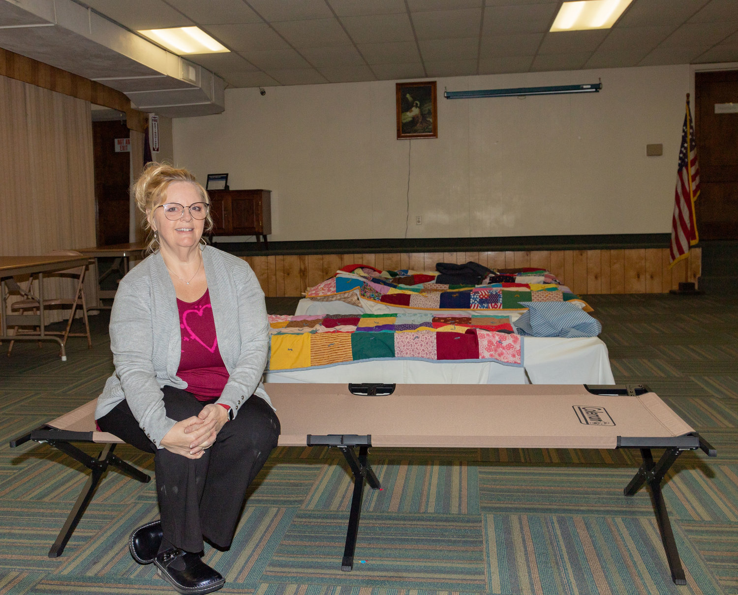 Paula Heath, a coordinator of Room at the Inn, sits on one of the cots prepared for guests at the over-night warming center last week. Heath would like the center to open more often, but she doesn’t have enough volunteers.