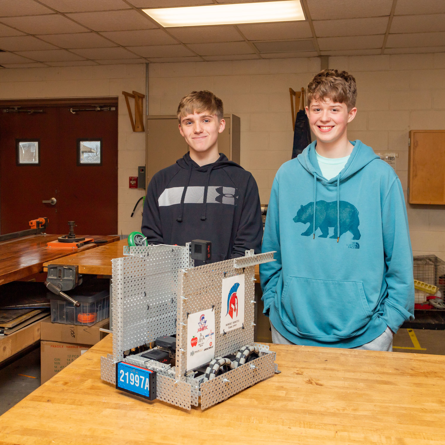 Gage Ferguson and Marshall Dixson pose with the robot the JROTC robotics team will take to state next month.