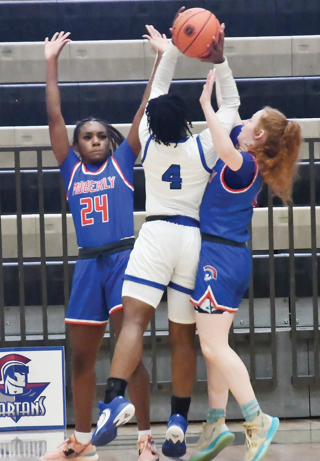 Moberly's Anyja Hayes (left), playing in her final scholastic game, and Haley Baker attempt to play defense on Rayvin Jones from Vashon during Saturday's Class 4 state quarterfinal at St. Charles.