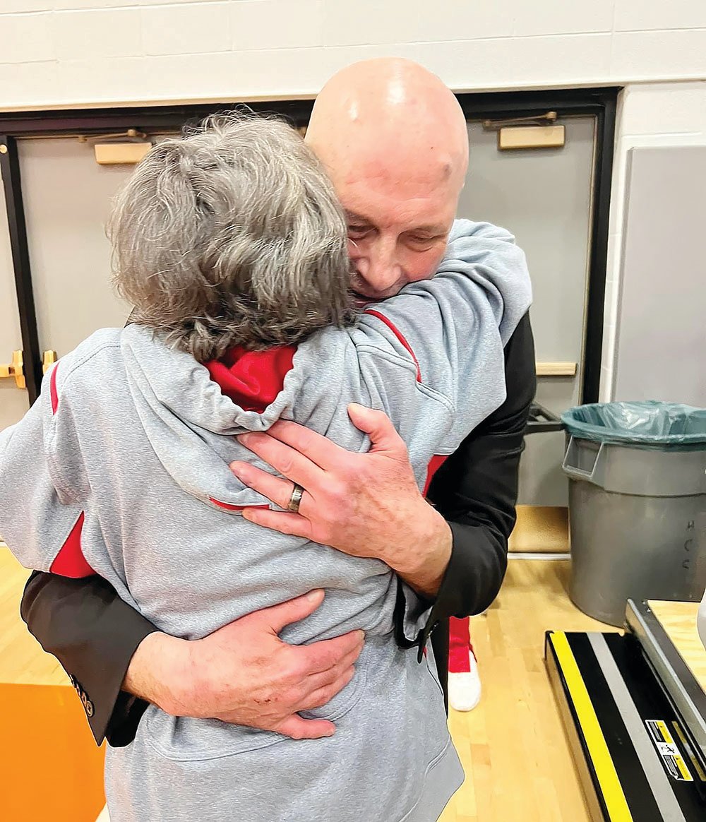 Head coach Pat Smith receives a hug from his mother, Sue Smith, after the Greyhounds defeated Highland, 66-52.