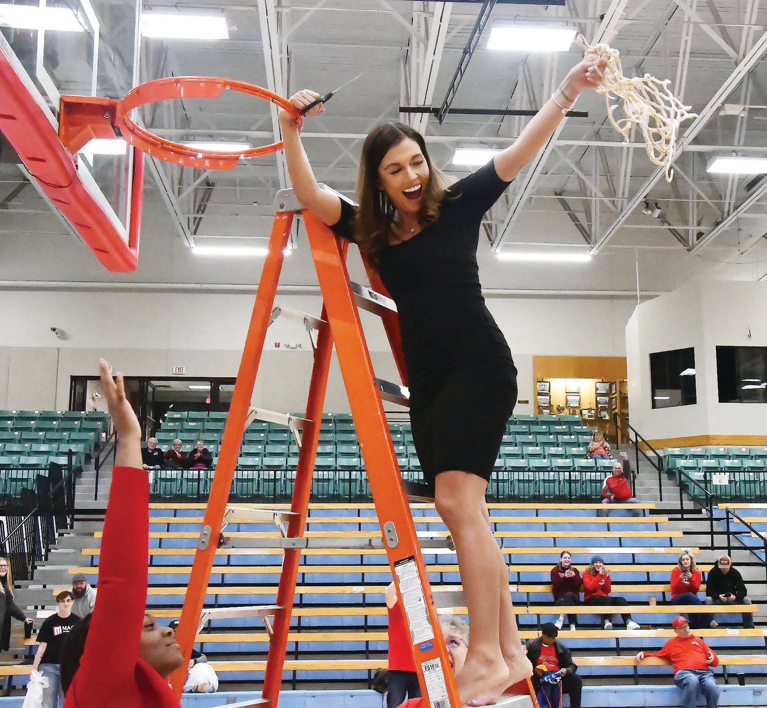 Moberly Area Community College head women's basketball coach Hana Haden swings the net in celebration after the Greyhounds defeated rival Mineral Area 78-57 for the Region XVI championship on Friday evening at Fitzsimmons-John Arena.