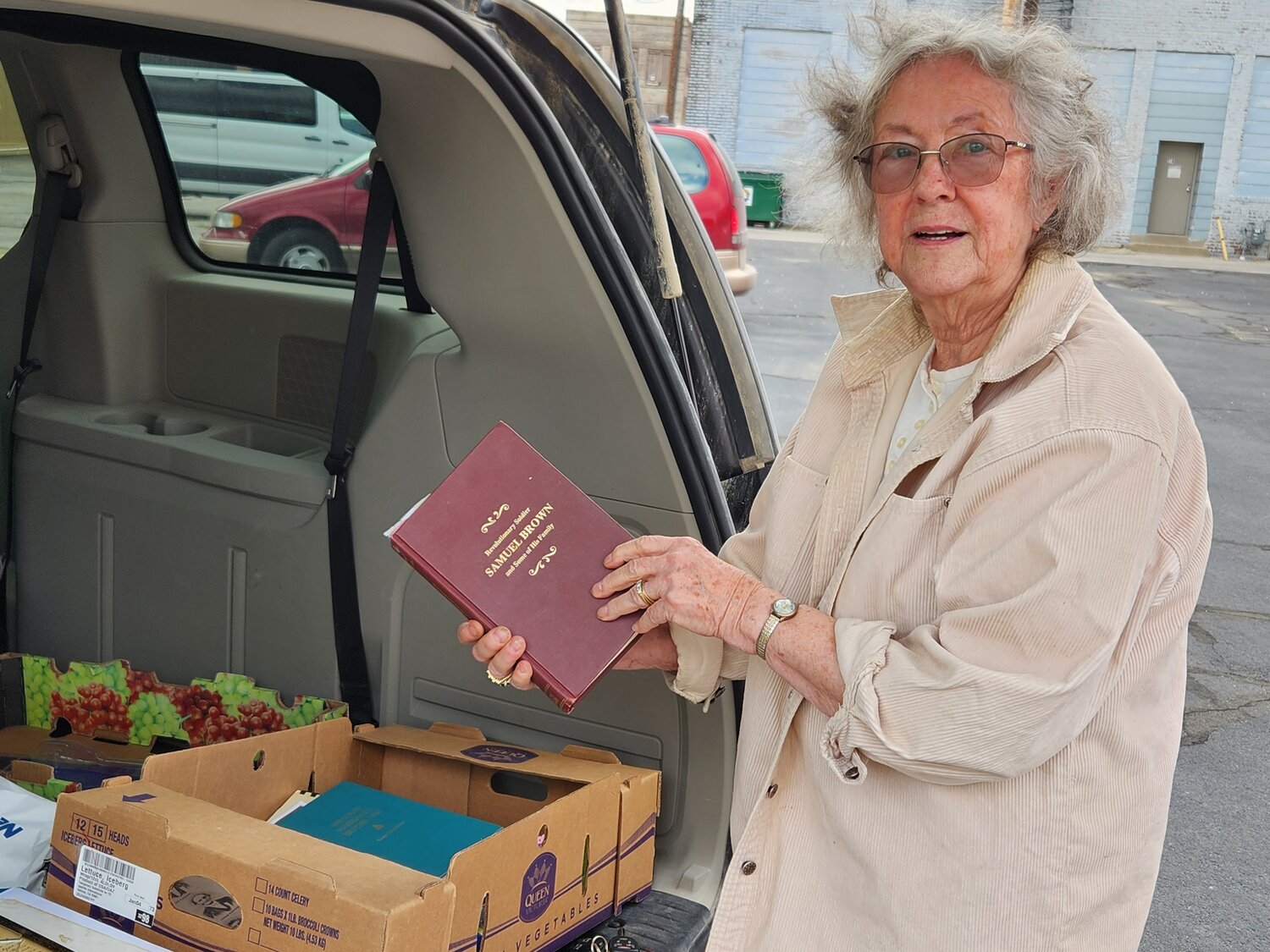 From a box in the back of her car, Joyce Campbell shows a favorite book about her fourth-great-grandfather Samuel Brown and his lineage. Campbell used the box full of genealogy materials during a recent talk in Boonsville.