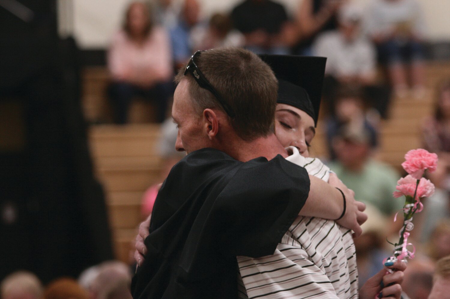 Abi Ogle hugs dad James Ogle and presents him with a carnation during Cairo’s commencement exercise May 14.