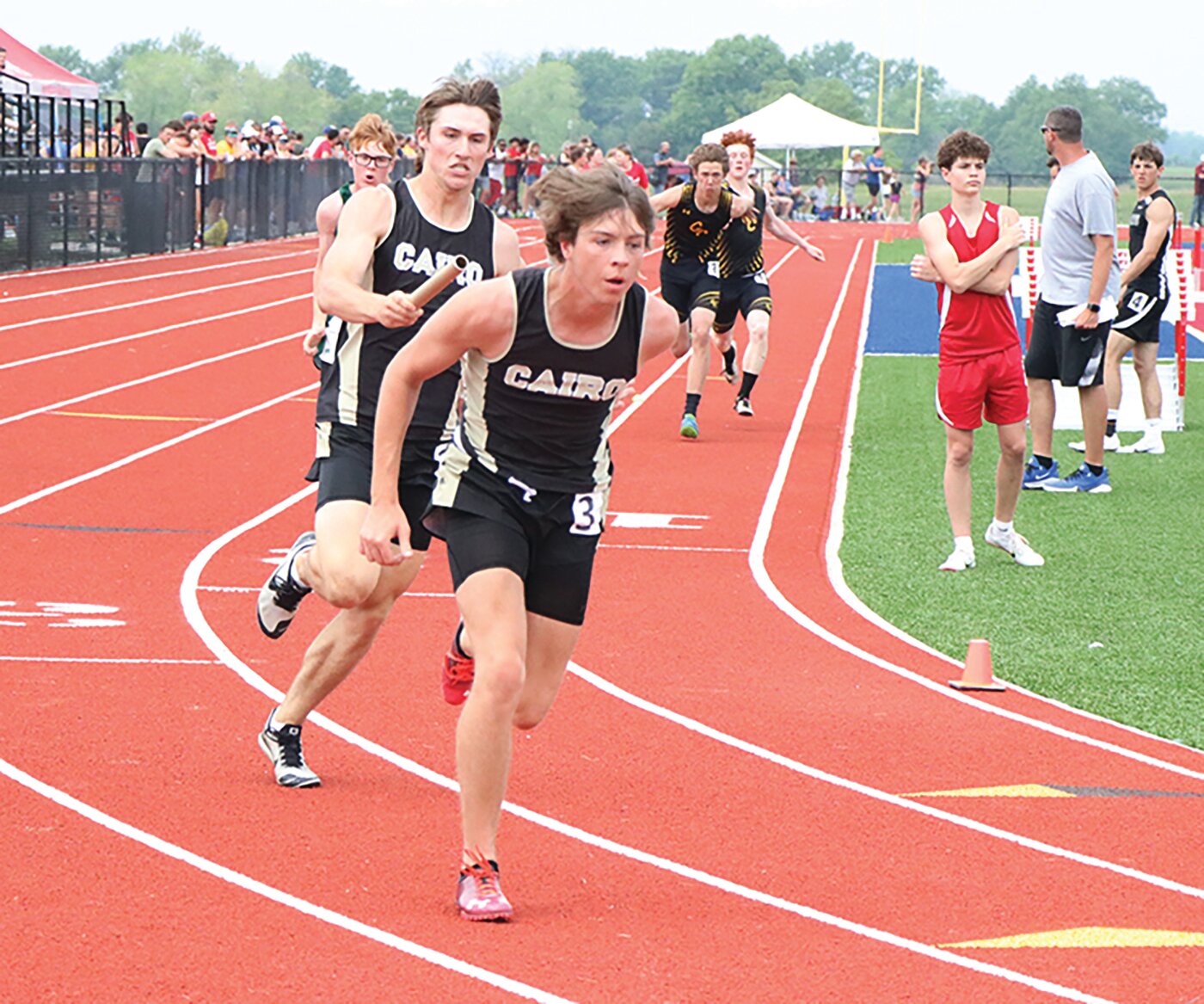 Cairo's Logan Head exchanges the baton to teammate Logan Hankins during the Class 1 sectional meet on Saturday, May 13.
