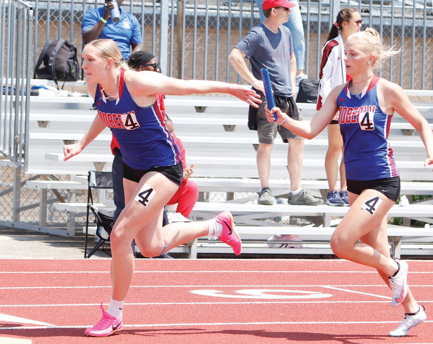 Moberly's Asa Fanning (left) accepts the baton from teammate Bryleigh Knox during the 4x200-meter relay at the Class 4 Section 2 meet on Saturday, May 20, at Ron Whittaker Track in Mexico.