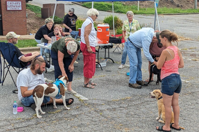 Dr. Don Hemstreet (blue shirt) tends to a pet while other unsheltered folks wait for their turn to see the vet at the Unsheltered Pet Clinic. Calvary Lutheran Church, Burke United Christian Ministries, and Morganton Animal Clinic combined their efforts and plan to continue the clinics on a regular basis.
