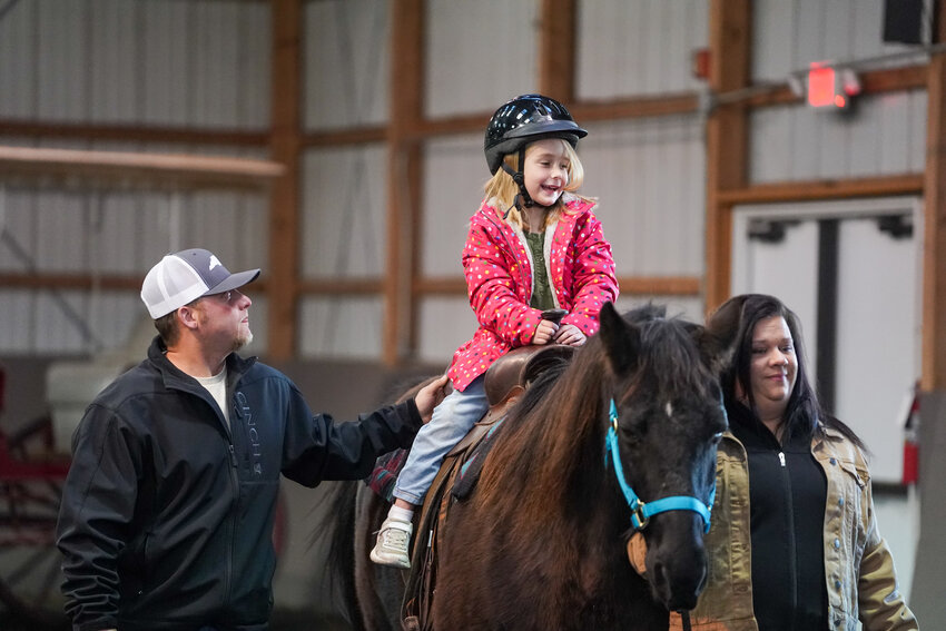 Gentry Hollifield beams a wide smile as she rides a horse during Christmas with the Horses at JIRDC in Morganton.