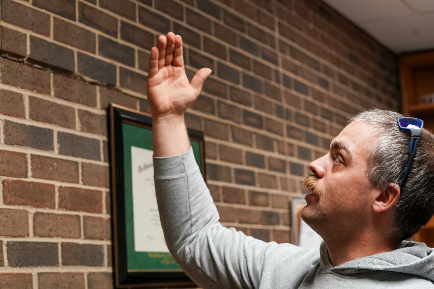 Valdese Fire Chief Truman Walton points out displaced bricks in the public safety building.
