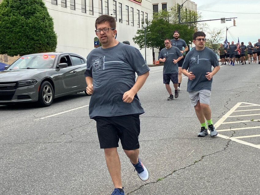 Burke County Special Olympic athletes run down South Sterling Street with Law Enforcement Torch runners on Friday, May 10.