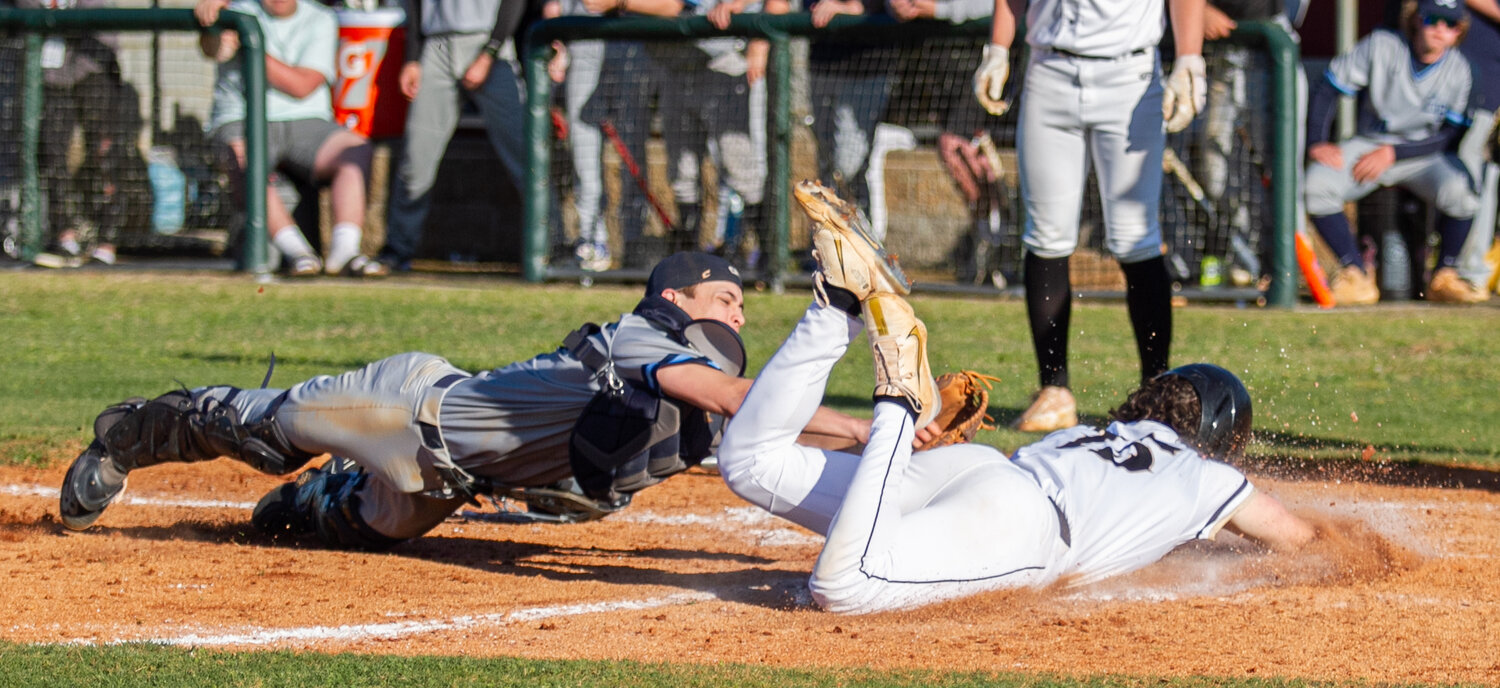 Draughn's Thomas Lambert slides safely home around a tag attempt from East Burke on Monday.