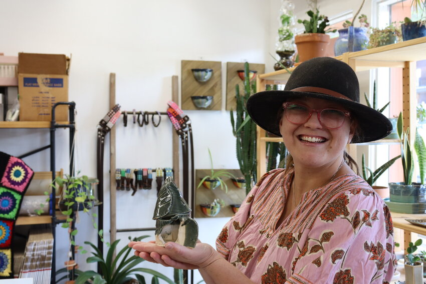 Brianna Rashbaum poses with a piece designed by one of her five-year-old students at Spinning Silica Art Collective.