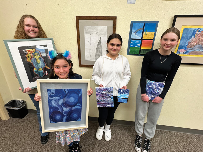 Artists in residenceLeo Simpson-Molochnick (high school), Riley Henderlong (elementary), Stormy Mumpy-Bruyer (middle school), and Addie Myhre (middle school) display their artwork that was recognized at the March 4 school board meeting.