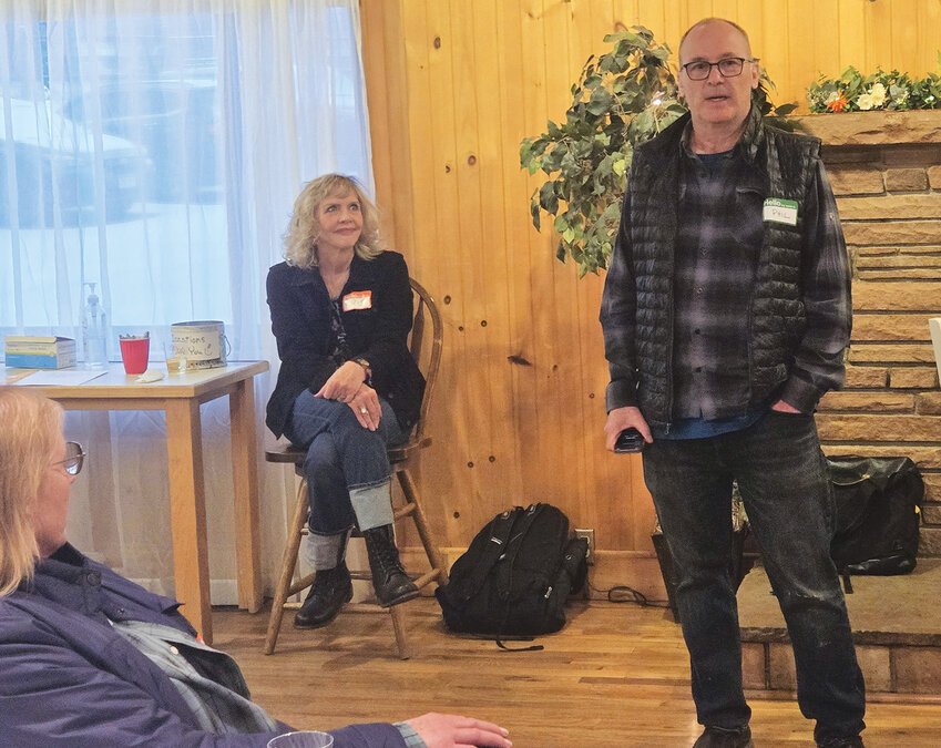 Part of the HubLynn Gibbs (left) and Kris Swedenborg (center) listen to the opening words of Phil Gibbs (right).