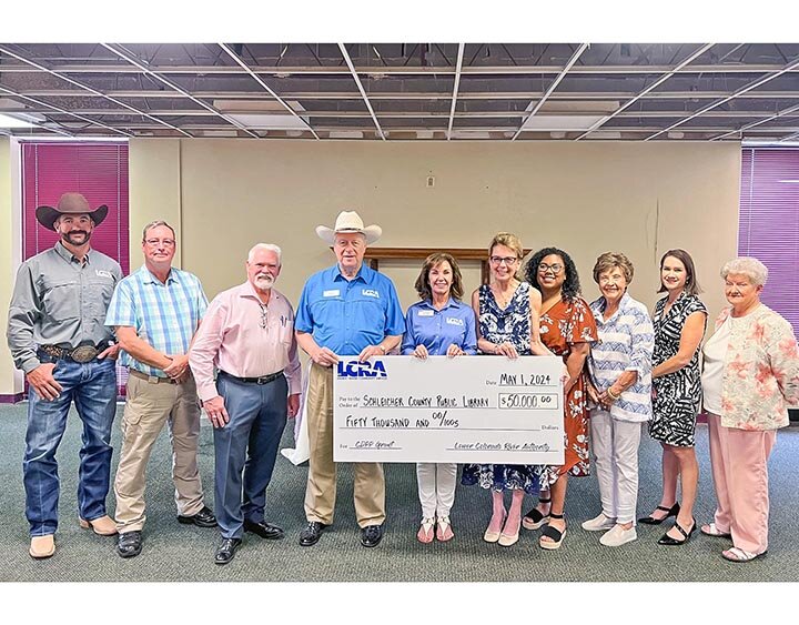 A NICE CHUNK OF CHANGE -- LCRA representatives present a $50,000 grant to the Schleicher County Public Library to help with its move to a new, larger building. The grant is part of LCRA’s Community Development Partnership Program. Pictured above are: (L-R) Cooper Hogg, LCRA regional affairs representative; David Doran, Eldorado Service Center president; Charlie Bradley, Schleicher County Judge; Michael L. “Mike” Allen and Carol Freeman, LCRA board members; Michele Bischoffberger, library director; Abigail Ussery and Sylvia Griffin, library board members; Jennifer Henderson, Eldorado Service Center vice president and treasurer; and Suzann McAngus, library assistant director. -- COURTESY PHOTO